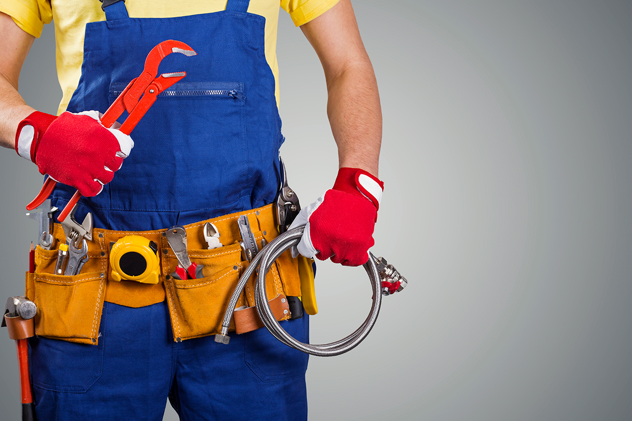 plumber with tool belt isolated on gray