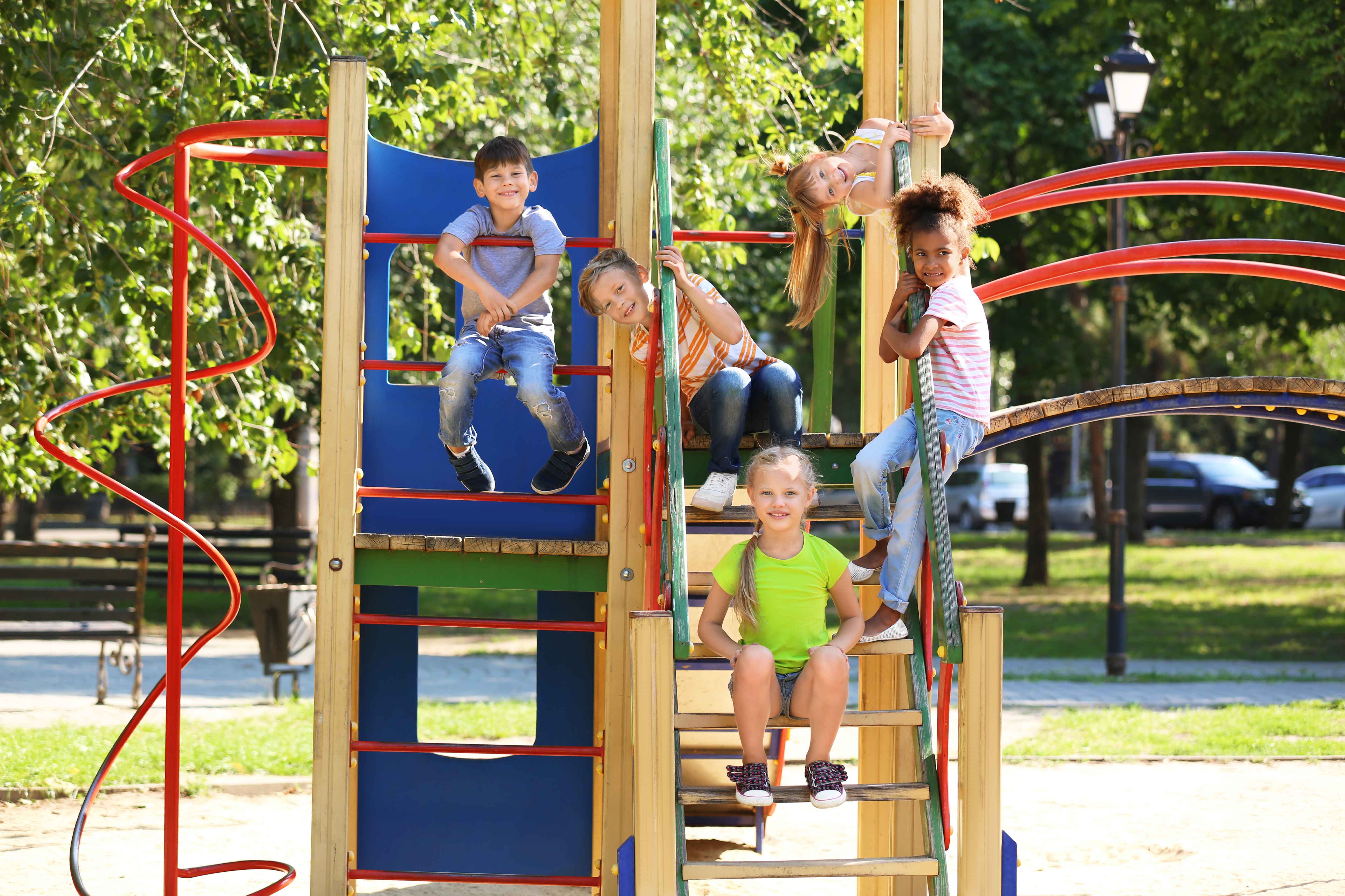 Cute-little-children-having-fun-on-playground-outdoors